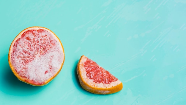 Free photo frozen grapefruit on turquoise background