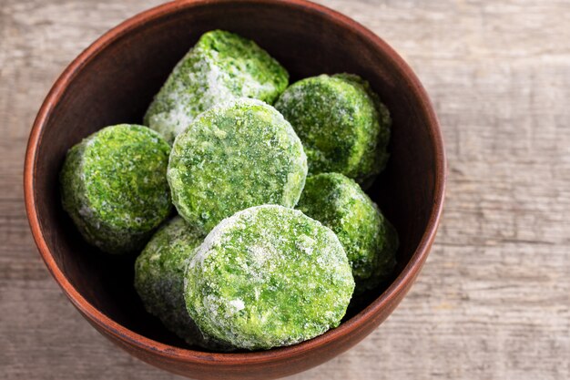 Frozen spinach on wooden background.