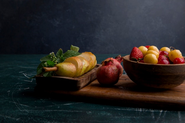 Fruit mix on a wooden platter isolated on blue space