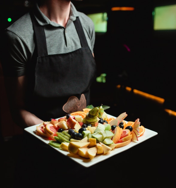 fruit plate on the hand of waiter