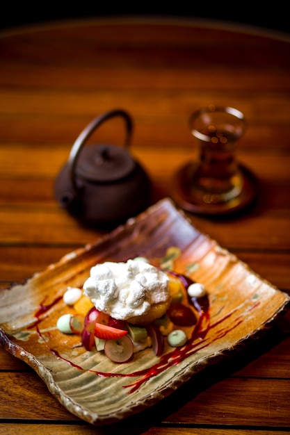 Fruit plate topped with cream and sugar powder