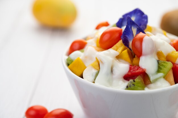 Fruit salad in a bowl on the wooden floor.