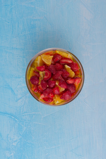 Fruit salad with strawberry and oranges, top view