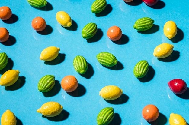 Free Photo fruit shape candies over the blue backdrop