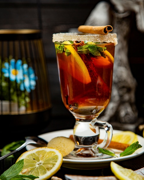 Fruit tea with lemon and cinnamon on the table