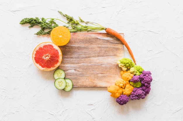 Free Photo fruits and cauliflower on wooden block over white texture background