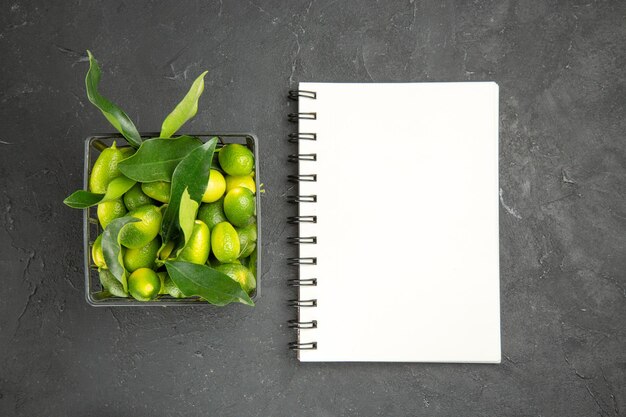 fruits citrus fruits with green leaves in the basket white notebook