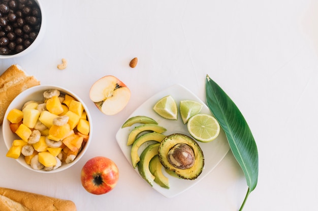 Fruits salad and bread on white backdrop