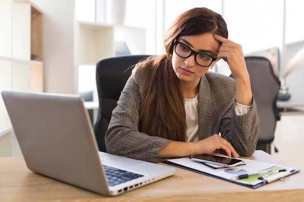 Frustrated businesswoman at desk with laptop