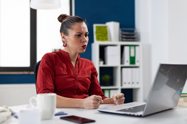 Frustrated businesswoman having problem with not working laptop