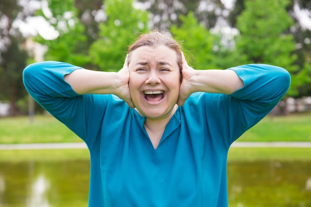 Frustrated unhappy woman suffering from loud sounds