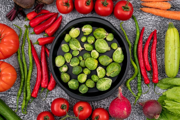 frying pan full with brussels sprouts surrounded by vegetables