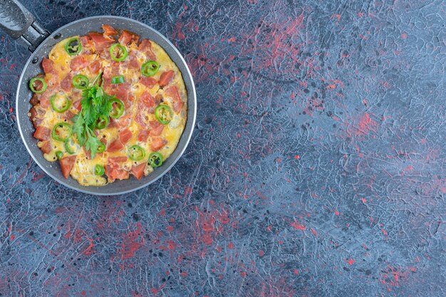 A frying pan of omelet with vegetables 