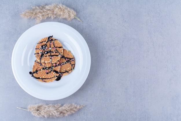 A frying pan of round ruddy waffle with sprinkles and cream