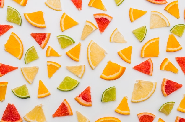 Full frame of triangular citrus fruits slices isolates on white background