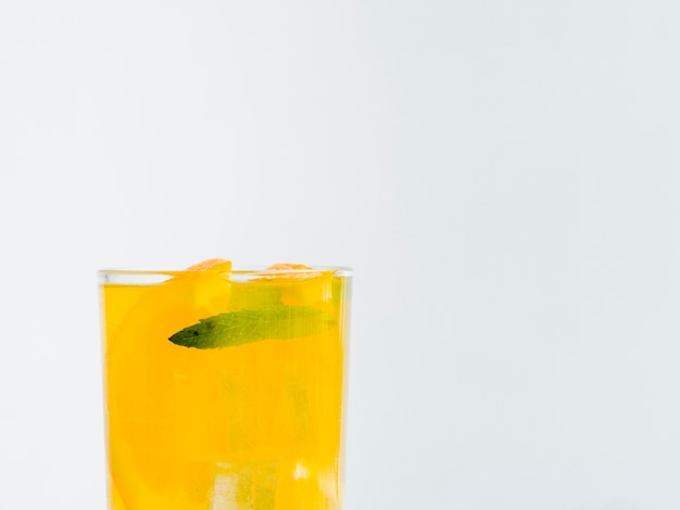 Full glass of orange juice with ice