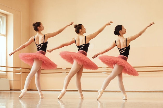 Free photo full length of ballerinas practicing together on ballet class at dance school