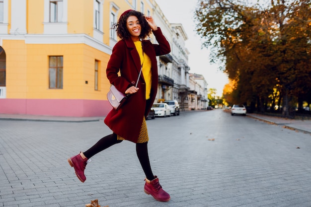 Full length image of  young  lady in  hat and wool coat jumping