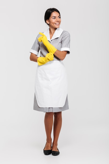 Free photo full length portrait of a attractive smiling housekeeper