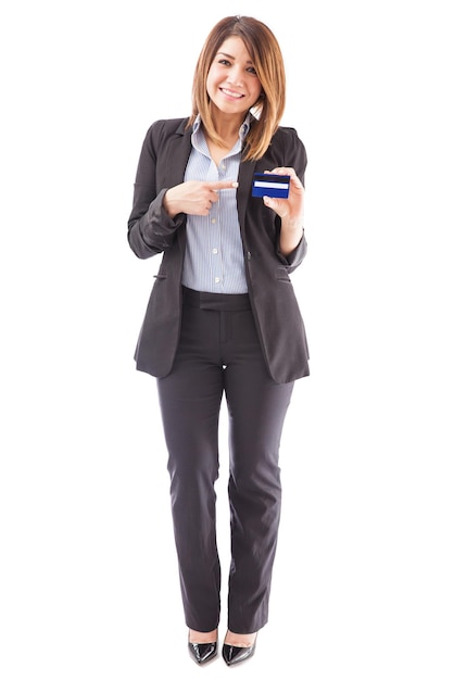 Full length portrait of a beautiful female bank representative pointing at a credit card and smiling