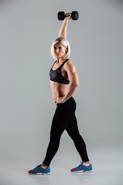 Full length portrait of a concentrated muscular sportswoman