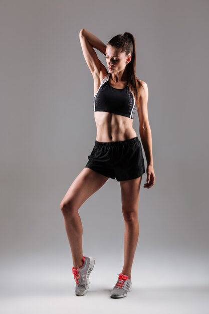 Full length portrait of a concentrated young fitness woman