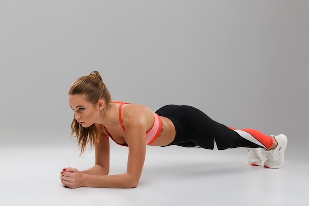 Free photo full length portrait of a pretty fit sportsgirl doing plank