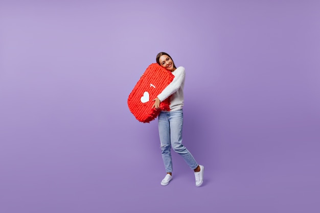 Free Photo full-length portrait of refined girl obsessed with social networks. well-dressed female blogger standing on purple