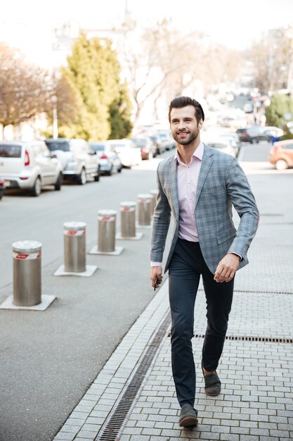 Free Photo full length portrait of a smiling handsome man in jacket