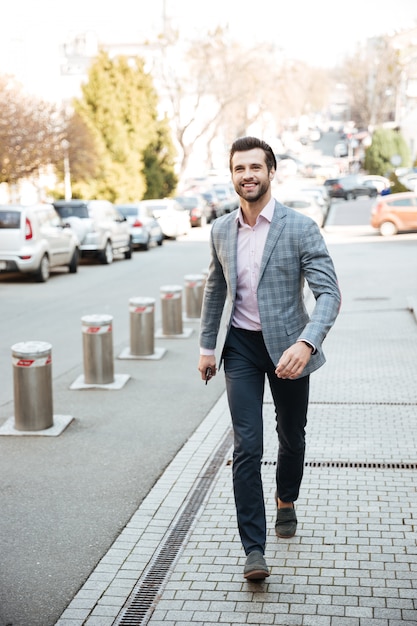 Free Photo full length portrait of a smiling handsome man in jacket