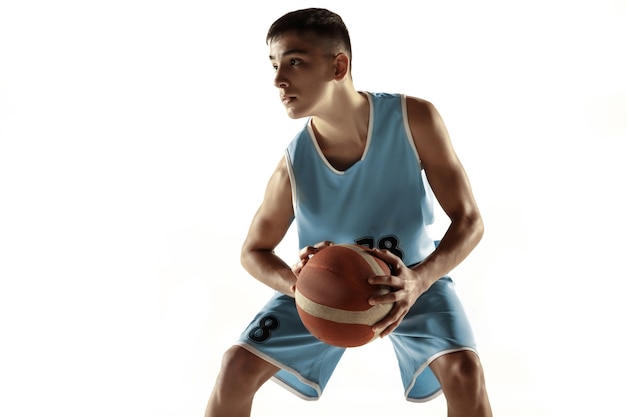 Full length portrait of young basketball player with a ball isolated on white studio background. Teenager training and practicing in action, motion. Concept of sport, movement, healthy lifestyle, ad.