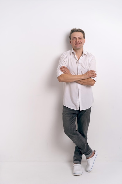 Free Photo full length portrait of young handsome man in white shirt and eye glasses smiling with a happy and confident positive expression with his arms crossed on a white background studio shoot