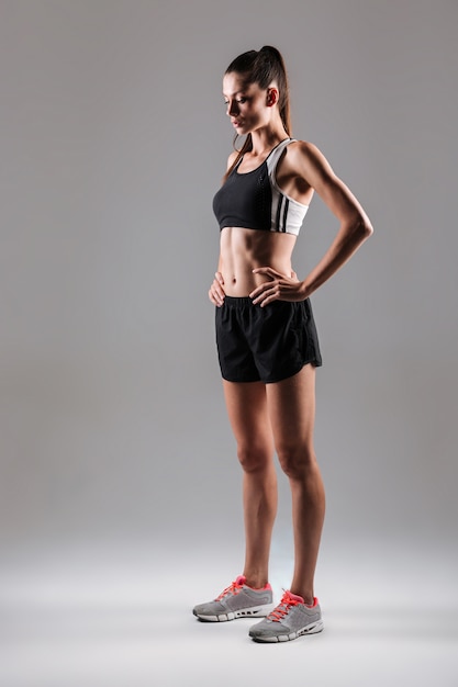 Full length portrait of a young slim fitness woman posing