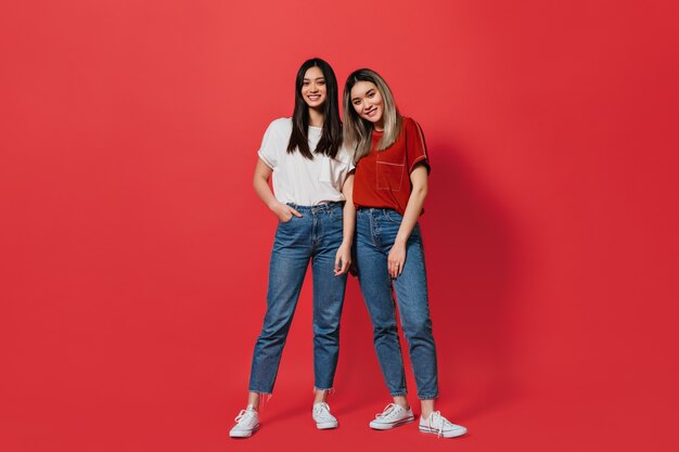 Full-length shot of women in identical jeans and similar T-shirts