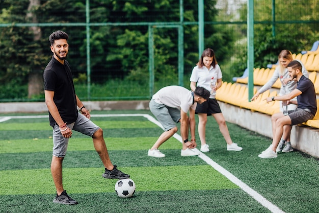 Free photo full length view of athletic african american soccer player staying with ball on green field