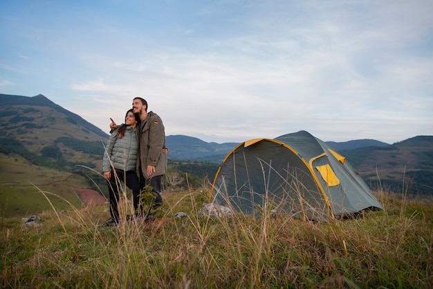 Full shot adventurous couple bivouacking