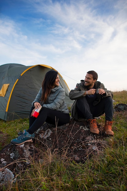 Full shot adventurous couple bivouacking