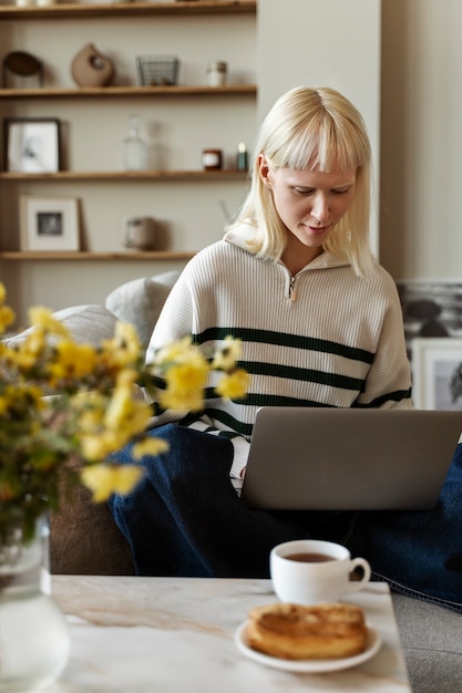 Full shot albino woman working on laptop