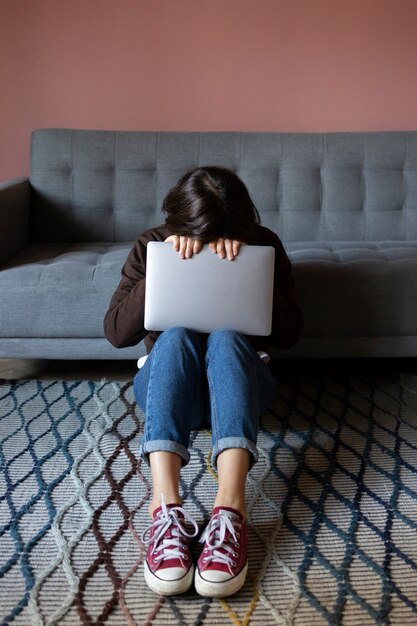 Full shot anxious woman holding laptop