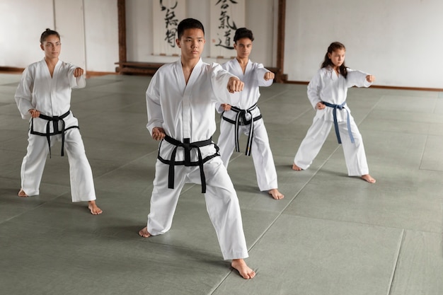 Free photo full shot asian people practicing taekwondo