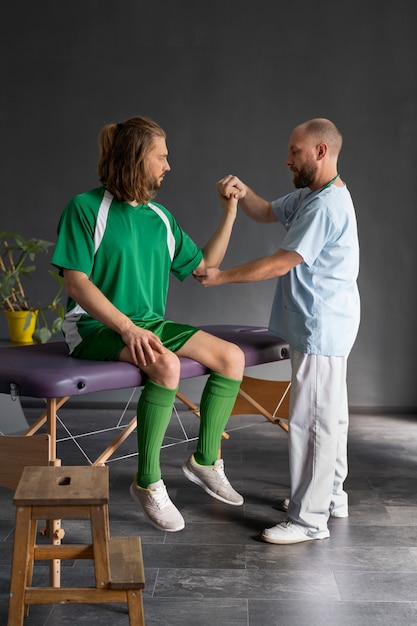 Free photo full shot athlete doing physiotherapy