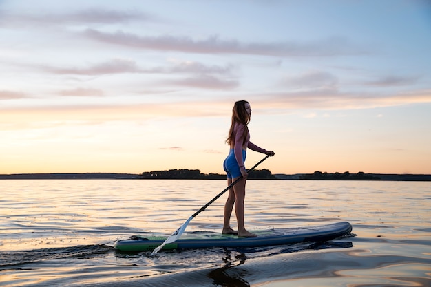 Full shot beautiful woman paddleboarding