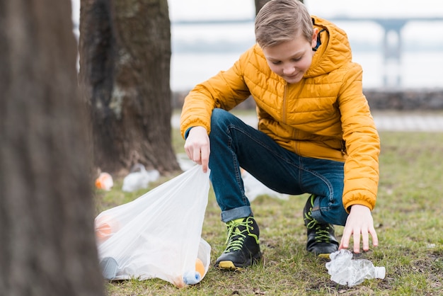 Free Photo full shot of boy cleaning the ground