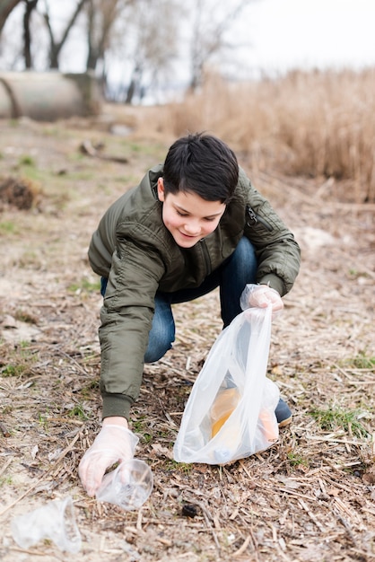 Full shot of boy cleaning the ground