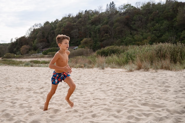 Free photo full shot boy  having fun at the beach