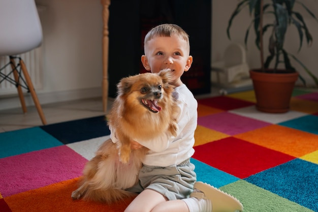 Free Photo full shot boy playing with dog indoors