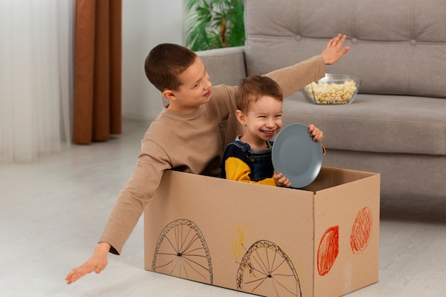 Full shot brothers playing with box