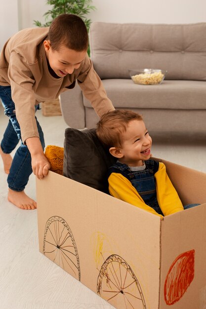 Full shot brothers playing with box