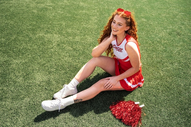 Full shot cheerleader sitting outdoors