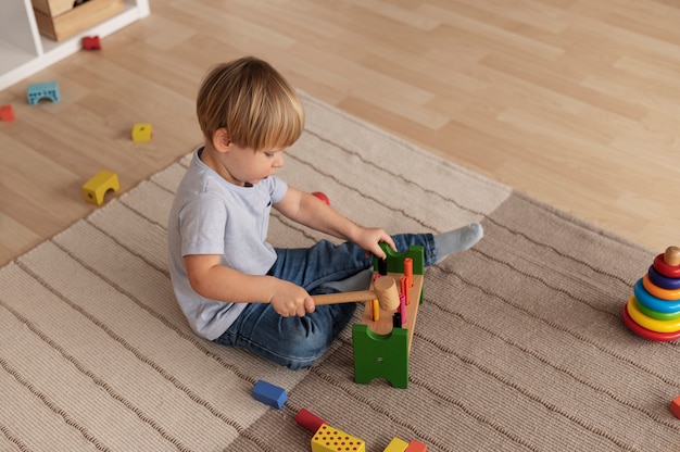 Free photo full shot child playing with wooden toys